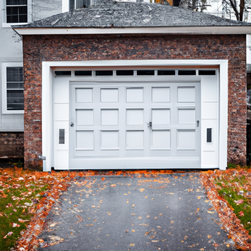 Insulated garage door on a Lexington, MA home with visible threshold and seals on an overcast late-fall day.